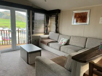 a living room with a couch and a table at Sea and Bay Viev Luxury Lodge in Clarach bay in Aberystwyth
