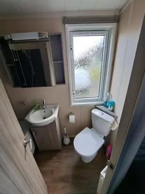 a small bathroom with a toilet and a sink at Sea and Bay Viev Luxury Lodge in Clarach bay in Aberystwyth