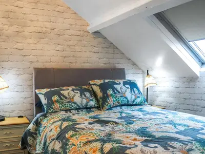 a bedroom with a bed and a brick wall at Brig Y Don in Borth