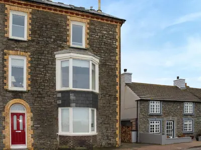 a brick house with a red door at Brig Y Don in Borth