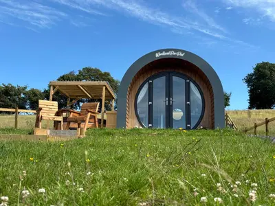 a circular building on a grassy hill with a field at Four Paws Glamping in Aberystwyth