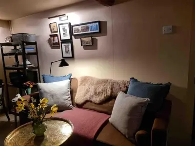 a living room with a couch with pillows and a table at Pont Wrysgen Cottage 'the gateway to Snowdonia' in Mallwyd