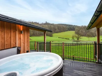a bath tub on a deck with a view at Lakeside Lodge - Uk50627 in Welshpool