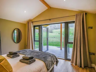 a bedroom with a bed and a large window at Lakeside Lodge - Uk50627 in Welshpool