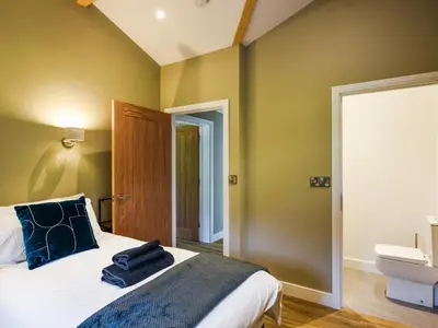 a bedroom with green walls and a bed and a toilet at Lakeside Lodge - Uk50627 in Welshpool