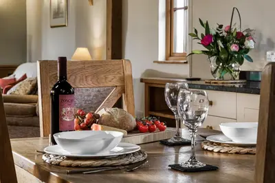 a table with a bottle of wine and a glass at Long Barn in Ludlow