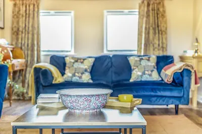 a living room with a blue couch and a table at 3 Bed in Lyonshall oc-h34806 in Lyonshall