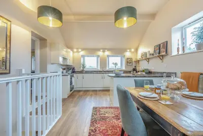 a kitchen and dining room with a wooden table and chairs at 3 Bed in Lyonshall oc-h34806 in Lyonshall