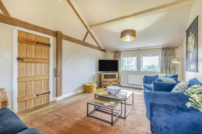 a living room with a blue couch and a table at 3 Bed in Lyonshall oc-h34806 in Lyonshall