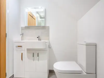 a white bathroom with a toilet and a sink at Arenig View - Uk51068 in Frongoch
