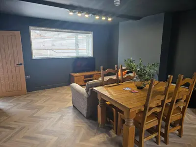 a dining room with a table and a couch at The Resting Place in Aberystwyth