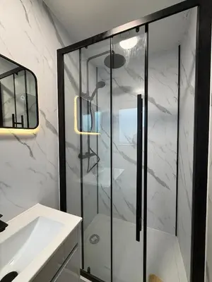 a bathroom with a glass shower and a sink at The Resting Place in Aberystwyth