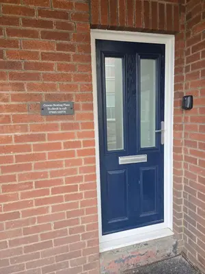 a blue door on the side of a brick building at The Resting Place in Aberystwyth