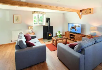 a living room with two couches and a fireplace at Orchard Farm in Ludlow