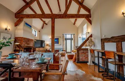 a living room with a wooden table and a dining room at 5 bedroom Barn, Ludlow in Caynham
