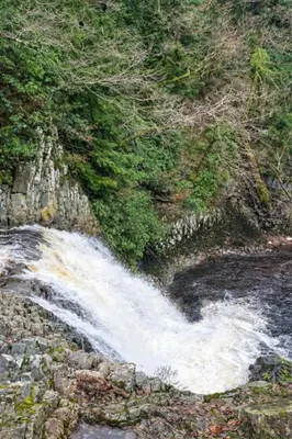 a waterfall on the side of a rocky hill at Ferndale Cottage in Church Stretton
