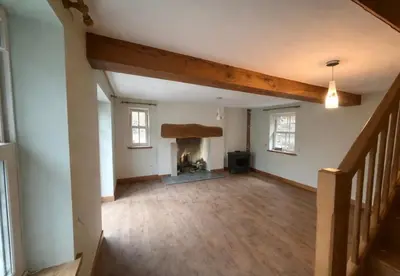 an empty room with a fireplace in a house at Ferndale Cottage in Church Stretton