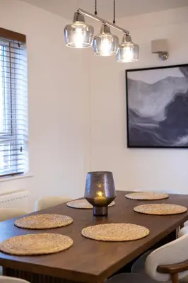 a dining room table with five chairs and a candle on it at Judith House in Shrewsbury