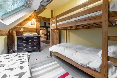 a bedroom with two bunk beds and a desk at Tanat Valley Farmhouse in Hirnant