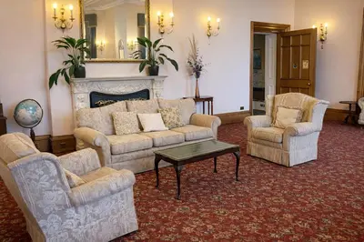 a living room with couches and chairs and a fireplace at Baskerville Hall Hotel in Clyro