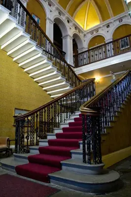 a spiral staircase in a building with red stairs at Baskerville Hall Hotel in Clyro