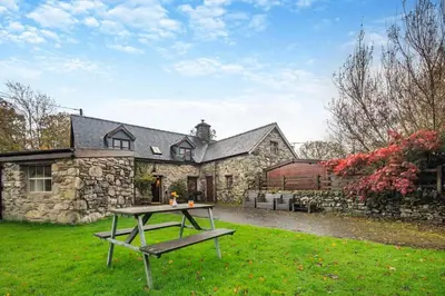 a stone house with a picnic table in front of it at 3 Bed in Dolgellau oc-24459 in Bont Newydd