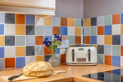 a toaster and a bread on a kitchen counter at 3 Bed in Dolgellau oc-24459 in Bont Newydd