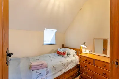 a bedroom with a bed and a dresser and a mirror at 3 Bed in Dolgellau oc-24459 in Bont Newydd