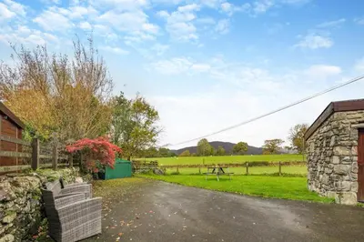 a house with a stone wall and a driveway at 3 Bed in Dolgellau oc-24459 in Bont Newydd