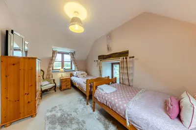 a bedroom with two beds and a window at 3 Bed in Dolgellau oc-24459 in Bont Newydd