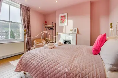 a bedroom with a bed with pink walls and a fireplace at 5 Bed in Llangollen oc-l34205 in Llangollen