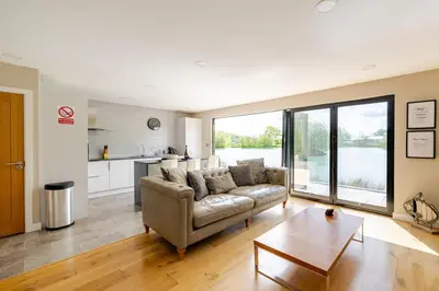 a living room with a couch and a table at Luxury Lakeside Lodge with Hot Tub in Ratlinghope in Ratlinghope
