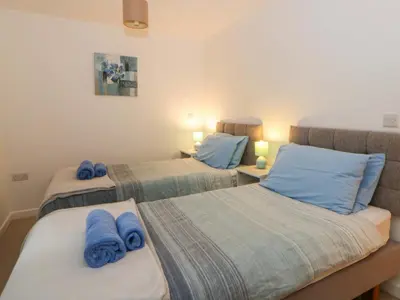 two beds in a room with blue towels on them at The Old Sunday School in Brecon