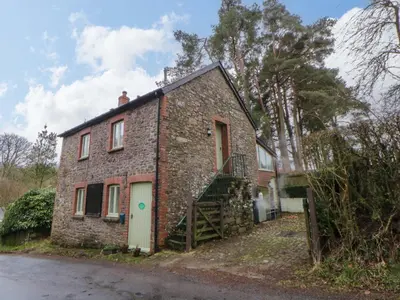 an old brick house with a staircase in front of it at The Old Sunday School in Brecon