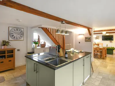 a kitchen with a sink and a clock on the wall at Lower House Barn in Staunton on Wye