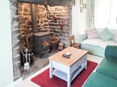 a living room with a couch and a fireplace at Canon's Cottage in Clun