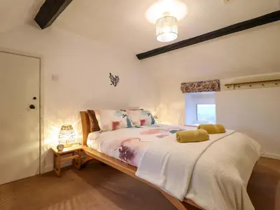 a bedroom with a large bed in a room at Bryn Y Garreg Cottage - The Wireless Tech Free Farm in Llangadfan