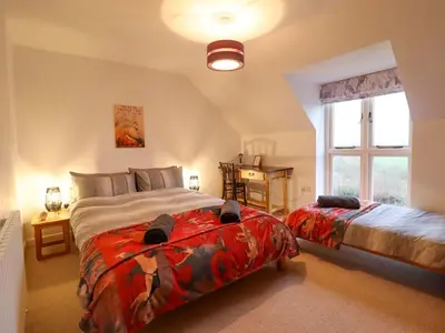 a bedroom with two beds and a window at Bryn Y Garreg Cottage - The Wireless Tech Free Farm in Llangadfan