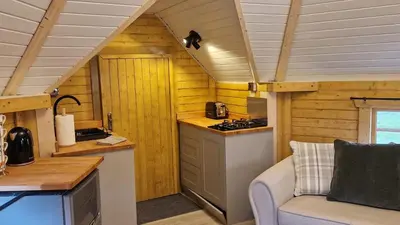 a kitchen in a tiny house with a couch at Oak Hill Escape in Welshpool
