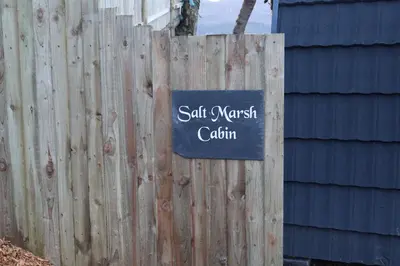 a sign on a fence that reads salt marsh coalition at Salt Marsh Cabin - Hot tub-Sauna in Barmouth