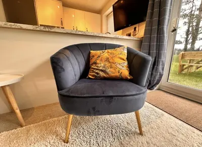 a black chair with a pillow in a living room at Pet friendly 3 bed retreat for beach, castle, golf in Harlech