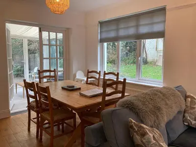 a dining room with a wooden table and chairs at Harlech castle and beach home in Harlech