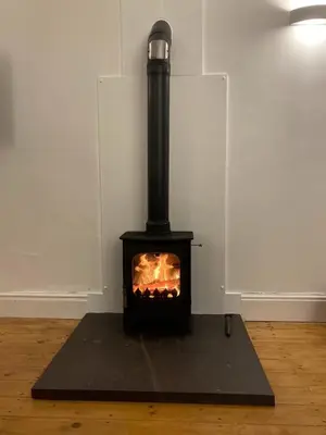 a black stove with a fire in a room at Harlech castle and beach home in Harlech