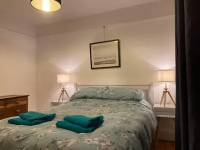 a bedroom with a bed with two green pillows on it at Harlech castle and beach home in Harlech