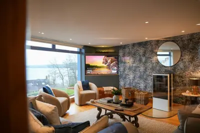a living room with a couch and a tv at Y Llofft in New Quay