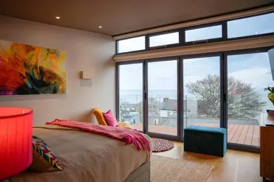 a bedroom with a bed and a large window at Y Llofft in New Quay