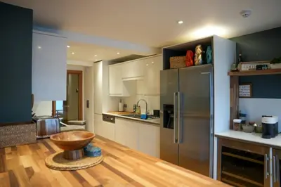 a kitchen with a wooden bowl in the middle of it at Y Llofft in New Quay