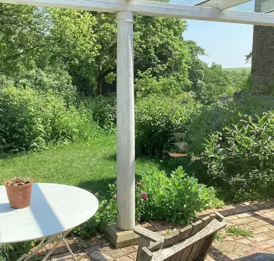 a white table and a pole in a garden at Off Grid living high in the hills in Picklescott