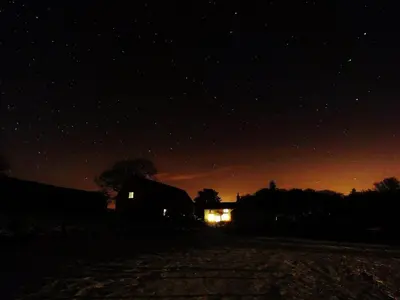 a house at night with the lights on at Off Grid living high in the hills in Picklescott