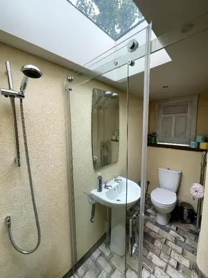 a bathroom with a shower and a toilet and a sink at Off Grid living high in the hills in Picklescott